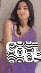 a woman in a purple dress is standing in front of a wall with the word cool on it
