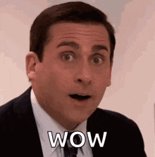a man in a suit and tie is making a surprised face while saying wow .