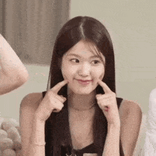 a woman is making a funny face with her fingers while looking at the camera .