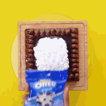 a bag of oreos is being poured on top of a cake