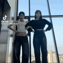 two girls are standing next to each other in front of a window and a sign that says tiktok