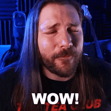 a man with long hair and a beard has the word wow written on his face
