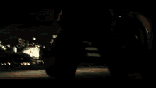 a man in a brown jacket is laying on the ground holding a sparkler