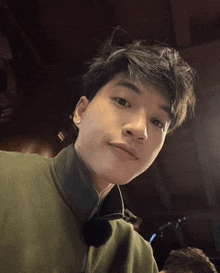 a close up of a young man 's face wearing a green jacket