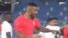 a soccer player in a red shirt with ssc on the bottom