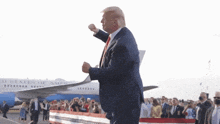 donald trump is standing in front of a united states of america airplane