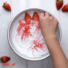 a person is mixing strawberries and whipped cream in a bowl that says yum up on the bottom