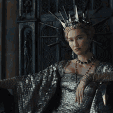 a woman wearing a black crown and a black armor