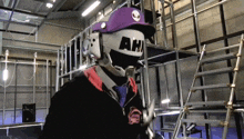 a person wearing a purple hat and a mask that says ah