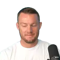 a man in a white shirt is holding a pair of headphones in front of a microphone