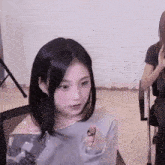 a young woman is sitting in a chair with her hands in her pockets and looking at the camera .