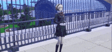 a girl in a school uniform is standing on a balcony with a fence in the background .
