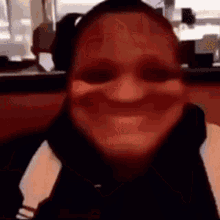a close up of a woman making a funny face while sitting at a table .