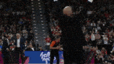 a man in a black suit stands in front of a basketball player wearing a green jersey with the number 1 on it