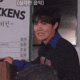 a man standing in front of a sign that says ' chickens ' on it