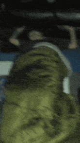 a blurry picture of a person laying in bed with a green blanket
