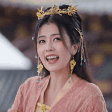 a woman wearing a crown and earrings is smiling with her mouth open