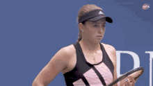 a woman is holding a tennis racquet in front of a wta logo