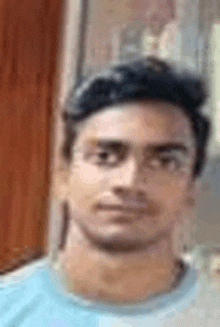 a close up of a man 's face wearing a blue shirt .
