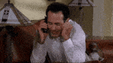 a man is laying on a couch talking on a phone
