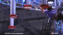 a man in a purple shirt is doing a trick on a nbc show