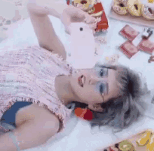 a woman is laying on the floor taking a picture with her phone