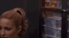 a cheerleader is sitting in front of a stack of boxes in a room .