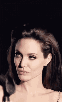 a close up of a woman 's face with a black background