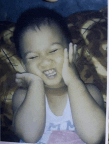 a young boy wearing a tank top that says mn on it
