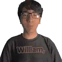 a man wearing glasses and a black shirt with the name william on it