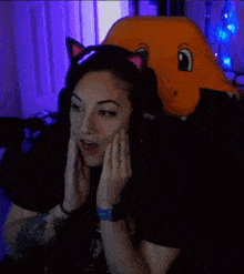 a woman wearing cat ears and headphones is sitting in a chair