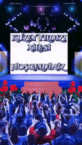 a crowd of people are gathered in front of a screen that says kuzey yildizi ailesi hosgeldiniz