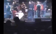 a group of people standing on a stage with the words r.i.p. juan gabriel in the corner