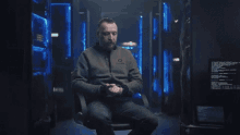 a man is sitting in a chair with a sweatshirt that says ' epsilon ' on it
