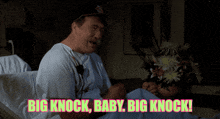 a man in a hospital bed with the words big knock baby big knock behind him