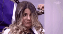 a woman is getting her hair blow dried by a man .