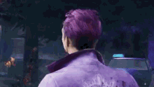 a man with purple hair is standing in front of a red car .