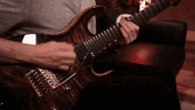 a man is playing an electric guitar while sitting on a couch .