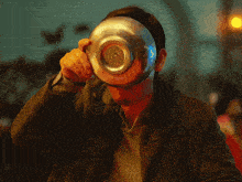 a man covering his face with a bowl
