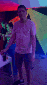 a man in a white t-shirt is standing in front of a table