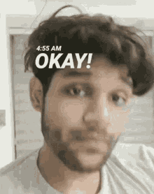 a close up of a man 's face with the words okay written on it