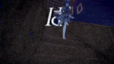 a girl in a blue dress is running in front of a wall with frames on it