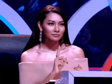 a woman sitting in front of a laptop with her hand on the screen
