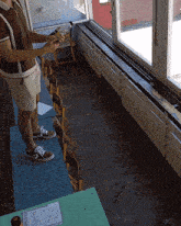 a man is standing in front of a window holding a book
