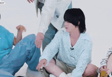 a group of people are sitting on the floor and one of them has a name tag that says ' a ' on it