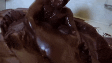 a large amount of chocolate is being poured on a person