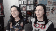 two women are sitting next to each other in a room .