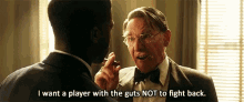 a man in a suit is talking to another man in a bow tie .