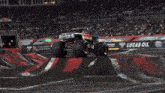 a monster truck with a red star on the side is on a track