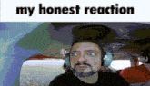 a man wearing headphones is sitting in a plane with the words my honest reaction above him